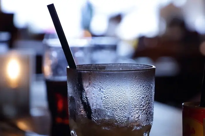 Photo of a glass of soda at a diner with a black straw